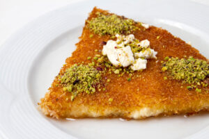 Kanafeh, knafeh boterig sliertjesdeeg gevuld met kaas en overgoten met siroop.